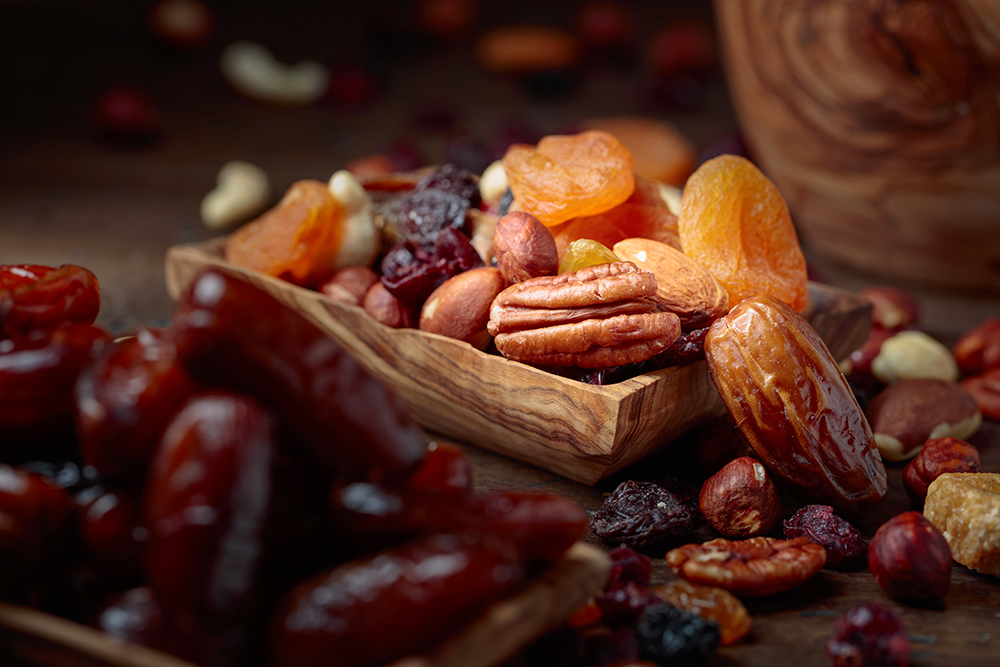 Various dried fruits and nuts on a old wooden table. Selective focus.